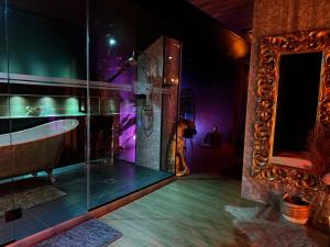 a bathroom with a bath tub and a mirror at Les Secrets Rooms - Verdun in Verdun-sur-Meuse