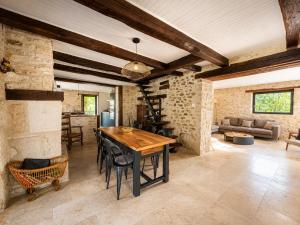 a kitchen and dining room with a wooden table and chairs at Authentique maison en pierre blanche du Quercy in Castelnau-de-Montratier +11 photos
