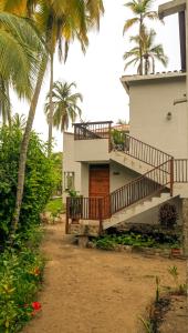 a house with a staircase and palm trees at Mystic Beach Resort in Guachaca