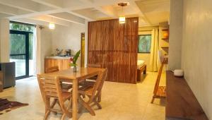 a dining room with a table and chairs and a kitchen at Mystic Beach Resort in Guachaca