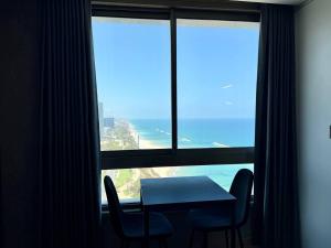 a table and chairs in a room with a large window at Sea Breeze Studios in Netanya