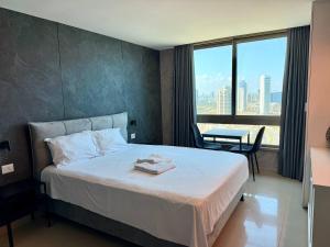 a hotel room with a bed and a view of a city at Sea Breeze Studios in Netanya