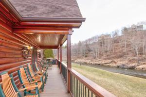 a porch of a cabin with chairs and a river at River Roost in Todd