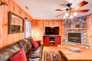 a living room with a leather couch and a fireplace at River Roost in Todd +42 photos
