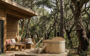 a wooden deck with a hot tub next to a tree at La forêt PALOMA, Ecolodge in Léon +31 photos