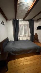 a bedroom with a large bed with a window at Arkan in Mykulychyn +34 photos