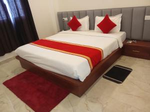 a bedroom with a large bed with red pillows at The Kalindi Hotel and Resort in Hamīrpur +10 photos