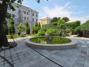 a fountain in the middle of a courtyard with a building at Ganja Hotel in Ganja