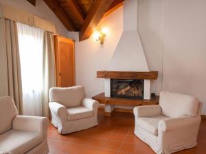 a living room with two chairs and a fireplace at Asiago Sporting Lodge - Buongiorno! Hotels in Asiago