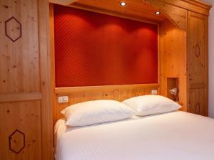 a bed with two white pillows in a room at Asiago Sporting Lodge - Buongiorno! Hotels in Asiago +8 photos