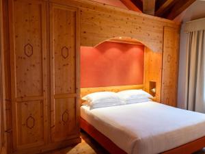 a bedroom with a bed with a wooden wall at Asiago Sporting Lodge - Buongiorno! Hotels in Asiago