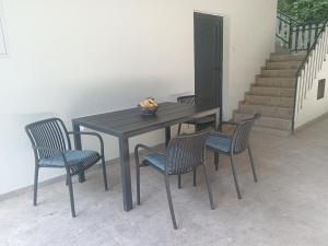 a table with four chairs and a bowl of fruit on it at Vikendica Coco in Gornja Toplica