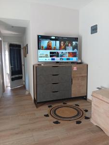 a living room with a flat screen tv on a dresser at Spartines home in Votsi