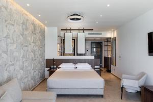 a bedroom with a bed and a couch at Margarita Sea Side Hotel in Kallithea Halkidikis