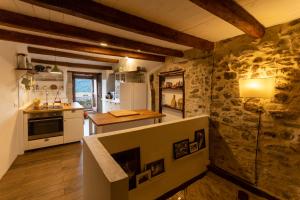 a kitchen with white appliances and a stone wall at La Casetta nel Borgo in Montalbano Elicona