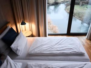 a bed in a room with a large window at Sternen Bohlingen Aparthotel in Bohlingen