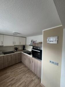 a kitchen with white cabinets and a stove top oven at Ferienwohnung bei Karl in Schmallenberg