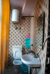 a small bathroom with a toilet and a sink at G N Hotel & Restaurant Bodla in Agra