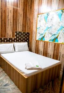 a large bed in a room with a painting on the wall at G N Hotel & Restaurant Bodla in Agra
