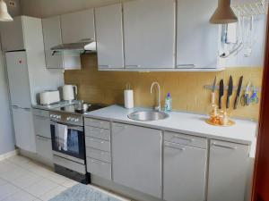 a kitchen with white cabinets and a sink at Charming Villa close to the sea in Errindlev +13 photos