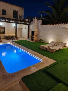 a swimming pool in the yard of a house at night at Casa Rural Gafas in El Toboso