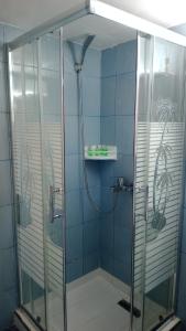 a shower in a bathroom with blue tiles at Magic Ionian Apartments & Rooms in Himare +253 photos