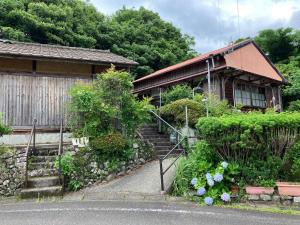 ein Haus mit Treppe und Blumen davor in der Unterkunft Nabiki in Hongu