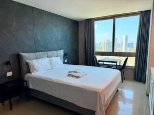 a hotel room with a bed and a large window at Sea Breeze Apartments in Netanya