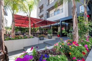 a patio with flowers in front of a building at Hotel Vino in Durrës