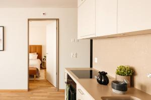 a kitchen with white cabinets and a bed in a room at Senevita Dreiklang in Lausen +5 photos