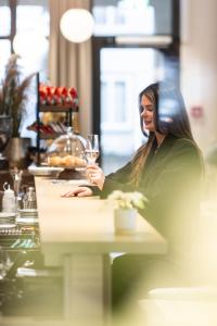 a woman sitting at a table with a glass of wine at Senevita Dreiklang in Lausen