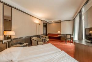 a hotel room with a bed and a television at Hotel Monopol Luzern in Lucerne