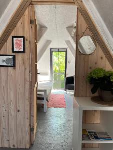 an attic room with a staircase and a bedroom at Piejūras Namiņš in Ragaciems