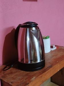 a silver tea kettle sitting on a wooden table at Hillside Highway Cottages in Shillong +27 photos