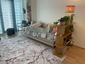 a living room with a couch and a rug at 1 studio seaview kalasatama Helsinki in Helsinki