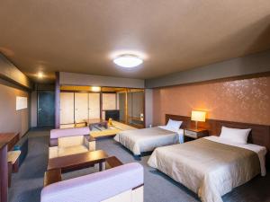 a hotel room with two beds and a couch at Hotel Kirishima Castle in Kirishima
