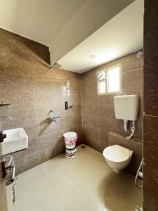 a bathroom with a toilet and a sink at TRPOTELS Formerly Hotel Sagar in Gwalior +17 photos