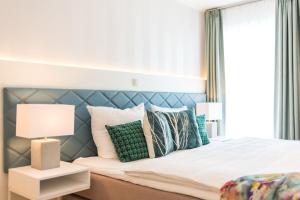 a bedroom with a bed with a blue headboard and pillows at Am Park 15 in Prerow