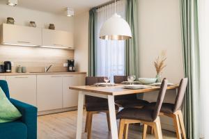 a kitchen and dining room with a wooden table and chairs at Am Park 15 in Prerow