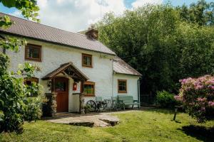 a white cottage with a picnic table in the yard at The Wilderness in Bromlow