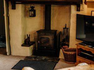 a fireplace in a living room with a television at The Wilderness in Bromlow