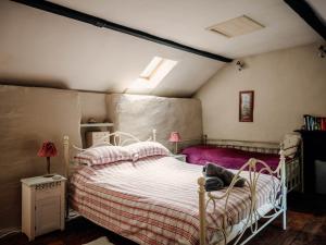 a bedroom with a white bed with pink sheets at The Wilderness in Bromlow