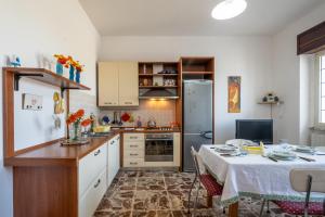 a kitchen with a table and a refrigerator at Casa Libeccio in Gagliano del Capo