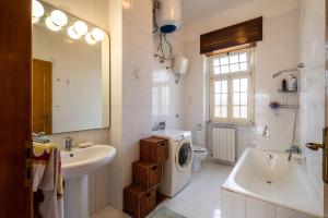 a bathroom with a sink and a washing machine in it at Casa Libeccio in Gagliano del Capo +11 photos