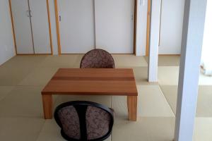 a table and two chairs and a table and cabinets at 萩別邸 翠 HAGI Bettei SUI in Hagi