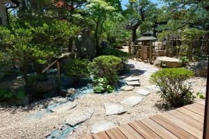 a garden with rocks and trees and a wooden walkway at 萩別邸 翠 HAGI Bettei SUI in Hagi +8 photos