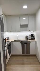 a kitchen with white cabinets and a sink and a refrigerator at Marina in Tampere