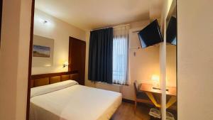 a hotel room with a bed and a desk and a window at U-Hotel Boutique Oria in Tolosa