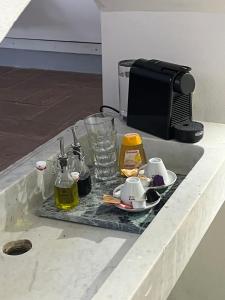 eine Theke mit einem Tablett mit Bechern und Flaschen Alkohol in der Unterkunft Le volte in Seravezza