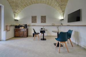 a room with chairs and a table and a tv at Agrù - Salento Garden Stay in Cavallino di Lecce